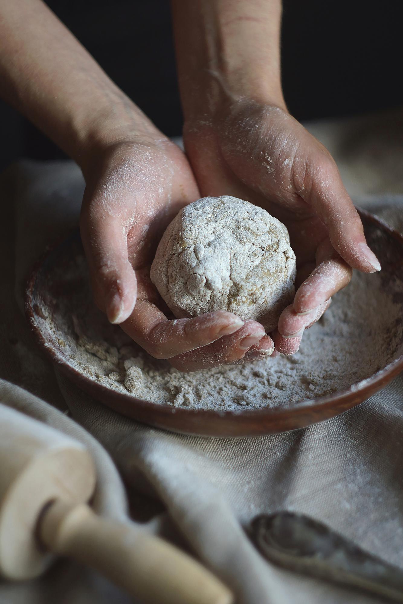 Close-up hands kneading dough